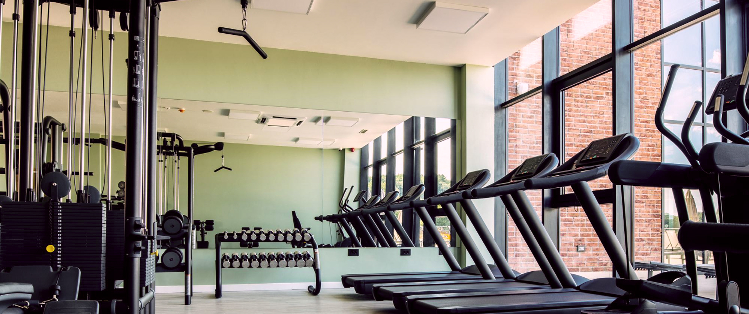 Спортзал с блоковым тренажёром, гантелями и беговыми дорожками